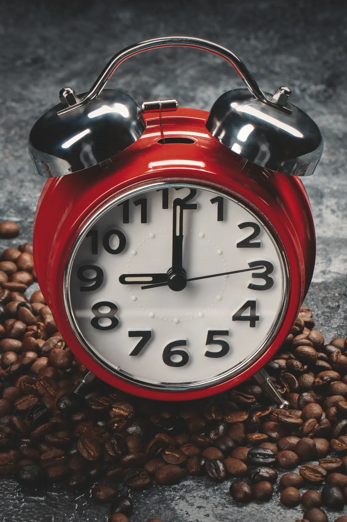 Front view of brown coffee seeds with clocks against a dark wall