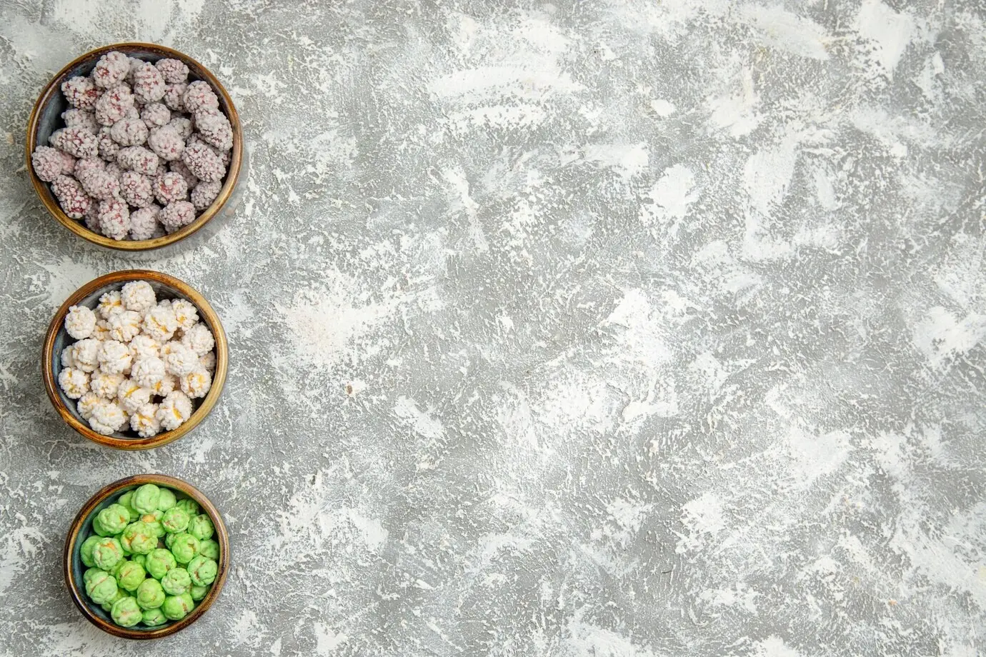 Top-down view of sugar candies in small plates on a white background; candy, sugar, bonbon, sweet, cookie.